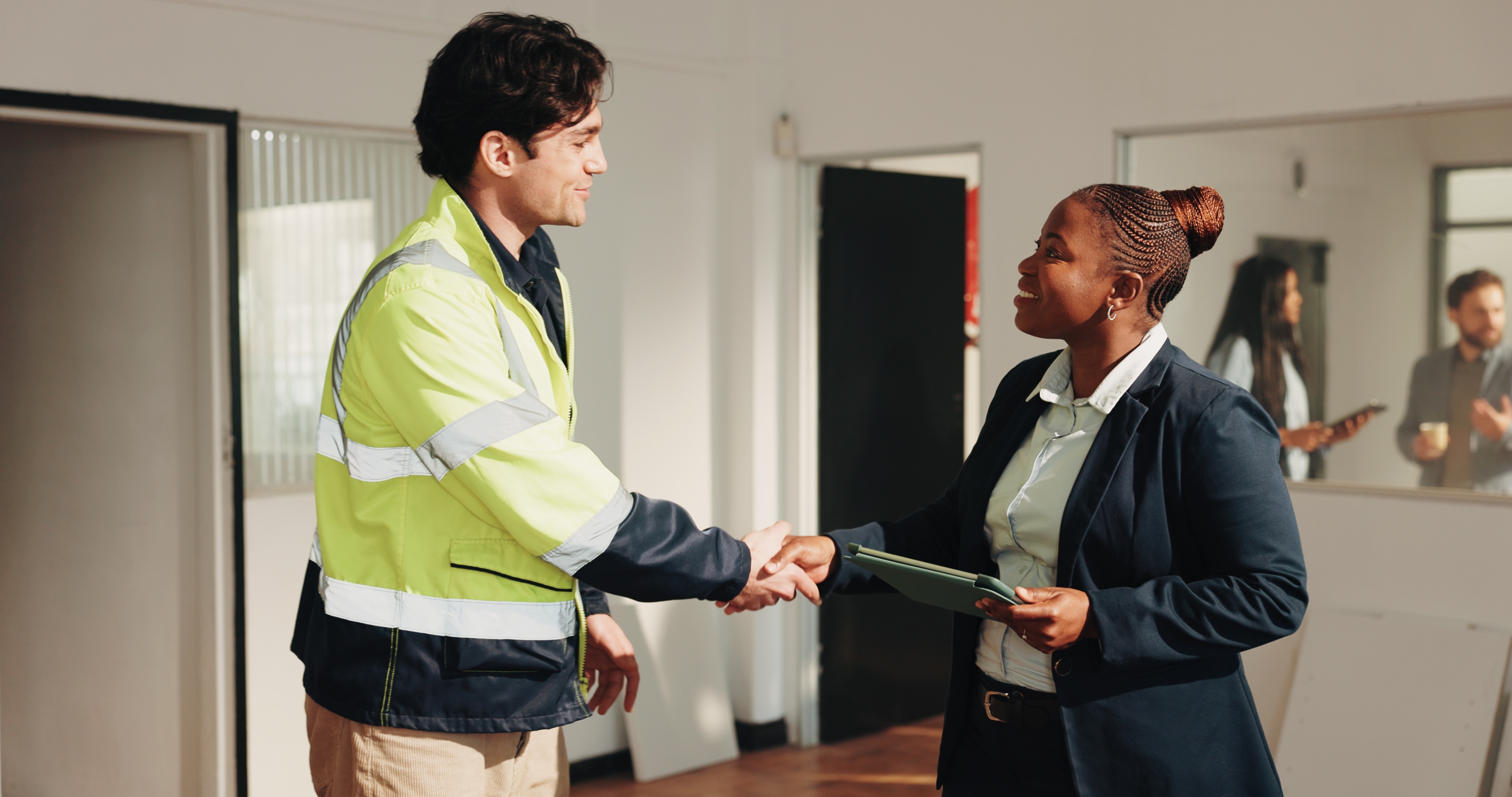 A home inspector shakes the hand of the property manager in a commercial building