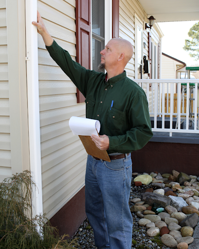 A home inspector checks the siding of a newly constructed home.